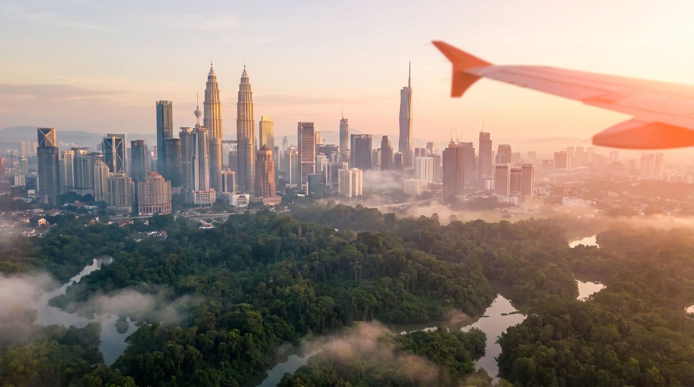 Widok na Kuala Lumpur o zmierzchu z dżunglą na pierwszym planie i wieżami Petronas Towers w tle.